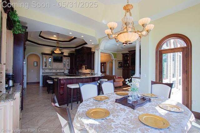 72755 Solanus Dr, Bruce, MI 48065 - dining space featuring arched walkways, a chandelier, decorative columns, ornamental molding, and a raised ceiling