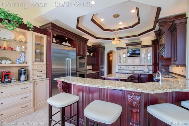 72755 Solanus Dr, Bruce, MI 48065 - kitchen featuring stainless steel appliances, arched walkways, decorative backsplash, glass insert cabinets, and a raised ceiling