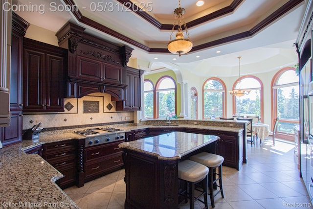 72755 Solanus Dr, Bruce, MI 48065 - kitchen with a raised ceiling, decorative columns, stainless steel gas cooktop, tasteful backsplash, and a center island