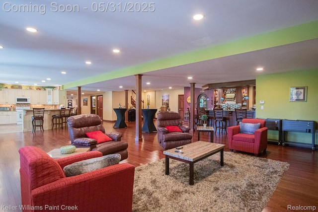 72755 Solanus Dr, Bruce, MI 48065 - living area with bar area, wood finished floors, recessed lighting, and decorative columns