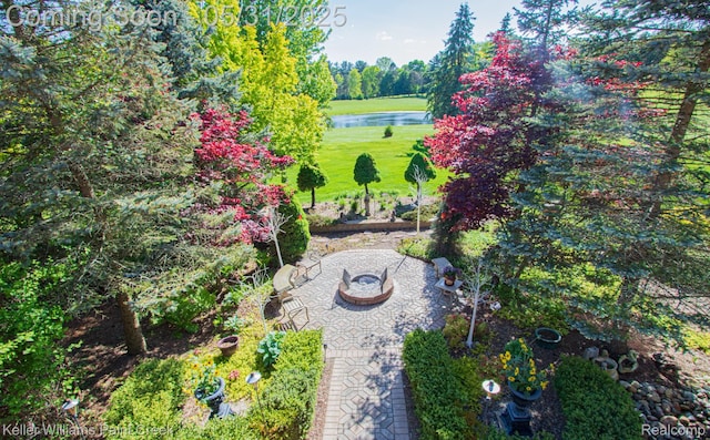 72755 Solanus Dr, Bruce, MI 48065 - view of grassy yard with a fire pit, a water view, and a patio