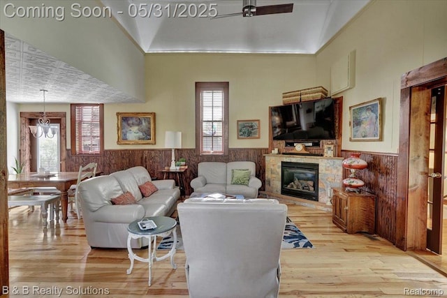 6624 Jefferson Rd, North Branch, MI 48461 - living room featuring a wainscoted wall, a fireplace, light wood-type flooring, plenty of natural light, and a chandelier