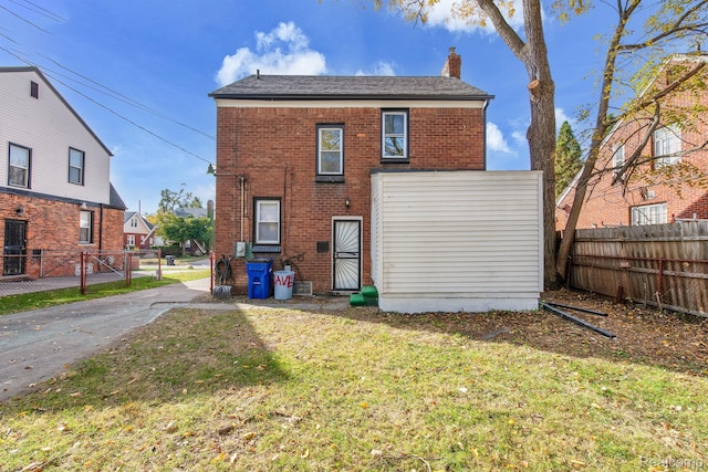 15480 Asbury Park, Detroit, MI 48227 - rear view of house with a chimney, brick siding, and a gate