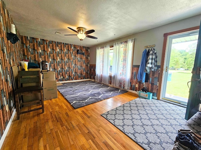 10040 S Reese Rd, Birch Run, MI 48415 - foyer entrance with a textured ceiling, wainscoting, wood finished floors, ceiling fan, and wooden walls