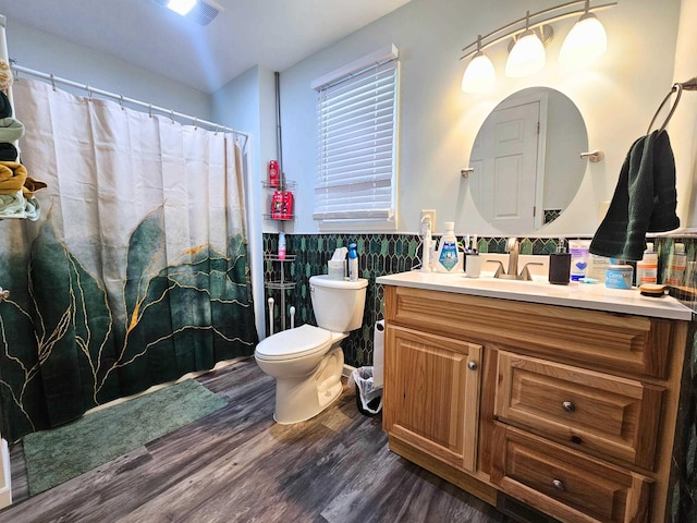 10040 S Reese Rd, Birch Run, MI 48415 - bathroom with wood finished floors, vanity, toilet, tile walls, and wainscoting