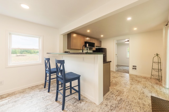 3687 111th Ave, Allegan, MI 49010 - kitchen featuring black appliances, dark countertops, a breakfast bar area, recessed lighting, and a peninsula