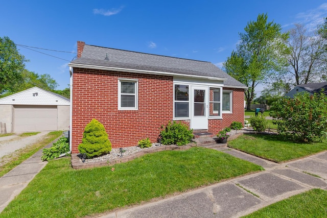 113 Greenleaf St, Onsted, MI 49265 - view of front of property with driveway, brick siding, a detached garage, and a front lawn