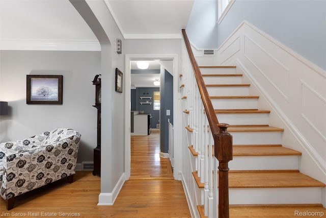480 Fisher Rd, Grosse Pointe Farms, MI 48230 - stairs with arched walkways, wood finished floors, and crown molding