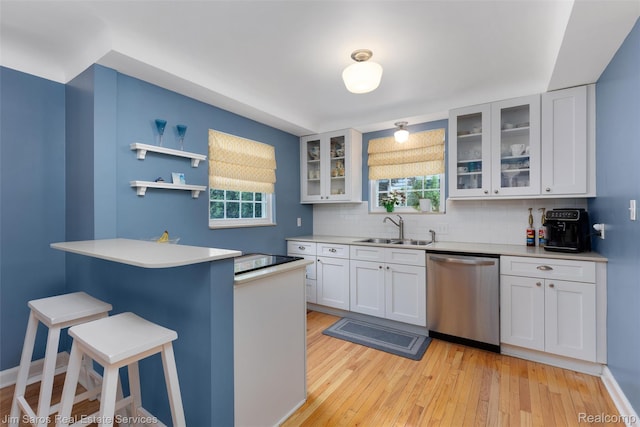 480 Fisher Rd, Grosse Pointe Farms, MI 48230 - kitchen featuring dishwasher, a sink, a kitchen bar, decorative backsplash, and a peninsula