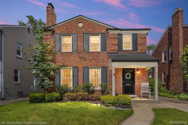 480 Fisher Rd, Grosse Pointe Farms, MI 48230 - view of front of house featuring brick siding, a porch, a chimney, and a front lawn