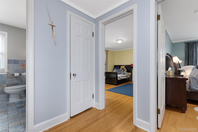 480 Fisher Rd, Grosse Pointe Farms, MI 48230 - hallway featuring light wood finished floors, tile walls, and ornamental molding