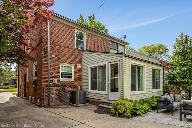 480 Fisher Rd, Grosse Pointe Farms, MI 48230 - back of property with central AC unit, a patio, an outdoor living space, entry steps, and brick siding