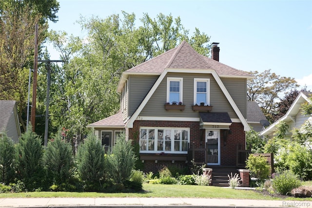 717 W 12 Mile Rd, Royal Oak, MI 48073 - view of front of home with roof with shingles, a chimney, brick siding, and a front lawn