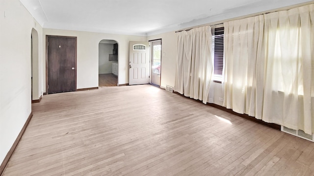 2127 E Coldwater Rd, Flint, MI 48505 - spare room with arched walkways, light wood-style flooring, and baseboards