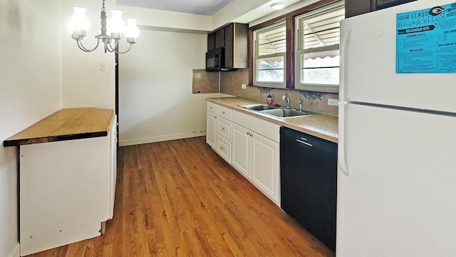2127 E Coldwater Rd, Flint, MI 48505 - kitchen featuring black appliances, a sink, light wood-style floors, white cabinets, and tasteful backsplash