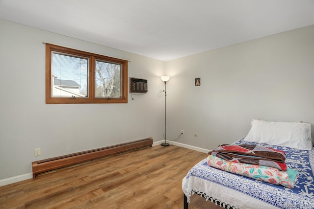 4173 Brandywyne Dr, Troy, MI 48098 - bedroom with a baseboard radiator, baseboards, light wood-style floors, and an AC wall unit
