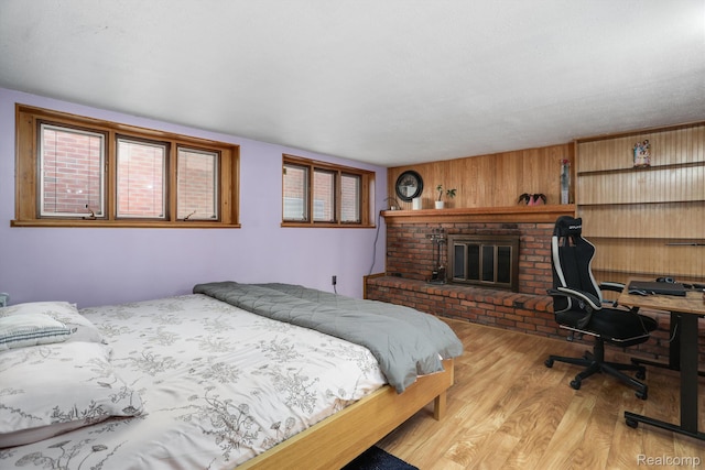 4173 Brandywyne Dr, Troy, MI 48098 - bedroom featuring light wood-style floors, a fireplace, and wood walls