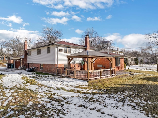 4173 Brandywyne Dr, Troy, MI 48098 - snow covered rear of property with a chimney, a gazebo, brick siding, and a garage