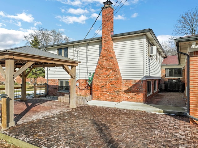 4173 Brandywyne Dr, Troy, MI 48098 - rear view of house with a gazebo, brick siding, a chimney, and a patio area