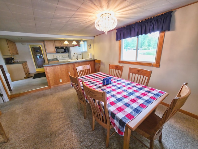 1352 Haughey Dr, Union City, MI 49094 - dining room with light colored carpet, a chandelier, and baseboards