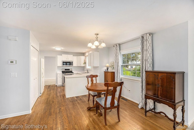 7674 Woodside Pl, Waterford, MI 48327 - dining area featuring wood finished floors, a chandelier, and baseboards