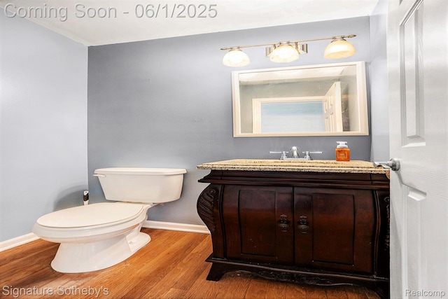 7674 Woodside Pl, Waterford, MI 48327 - bathroom with baseboards, toilet, vanity, and wood finished floors