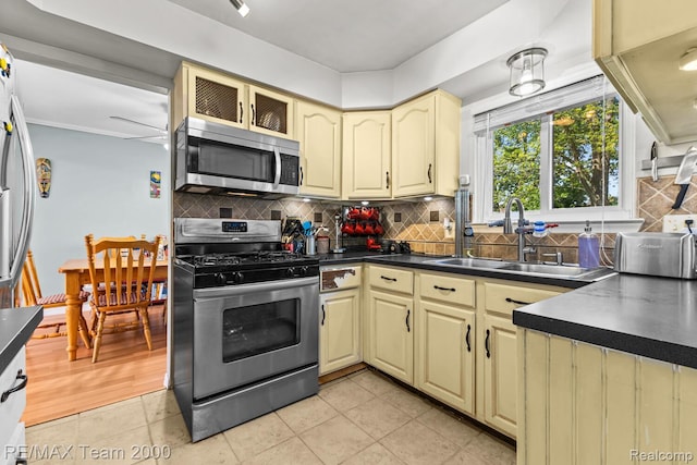 7485 Pointe Dr, Canton, MI 48187 - kitchen featuring stainless steel appliances, cream cabinetry, dark countertops, and a sink