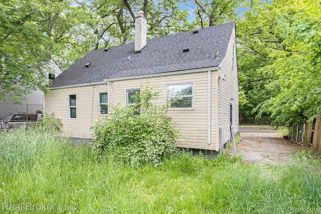19455 Houghton St, Detroit, MI 48219 - back of property featuring a chimney and roof with shingles