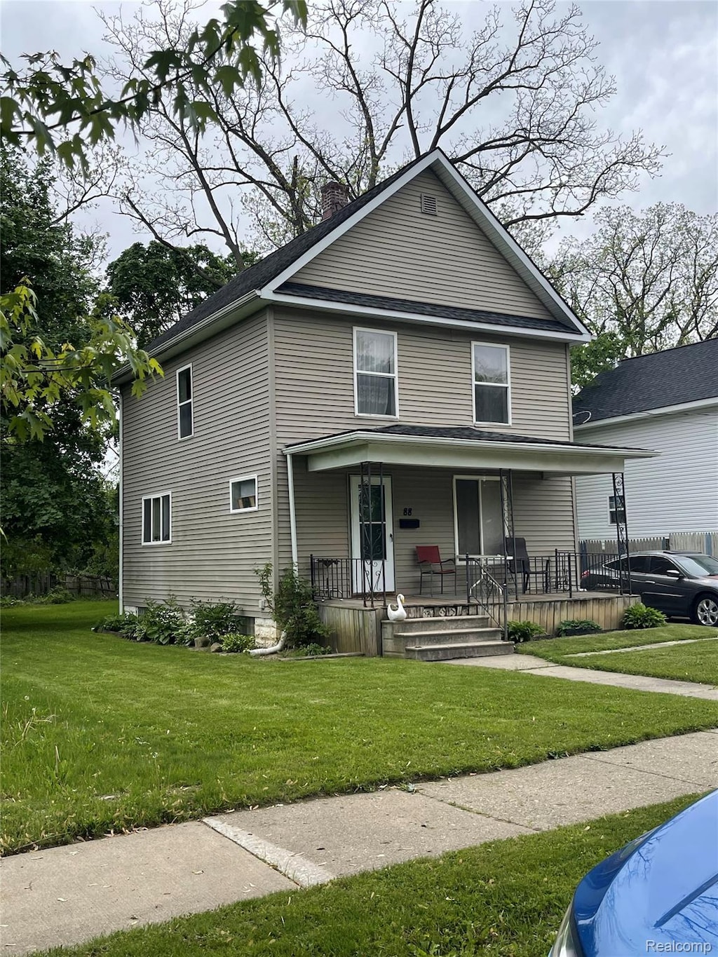 88 Thorpe St, Pontiac, MI 48341 - traditional style home featuring covered porch, a chimney, and a front lawn