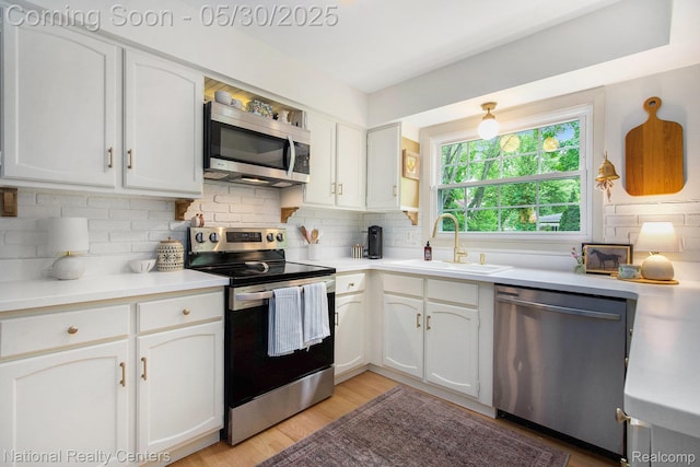 44947 Partridge Dr, Plymouth, MI 48170 - kitchen with stainless steel appliances, a sink, white cabinets, and tasteful backsplash