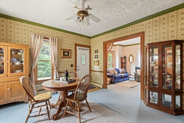 91 Dennison St, Oxford, MI 48371 - dining area with light colored carpet, wallpapered walls, ceiling fan, ornamental molding, and baseboard heating