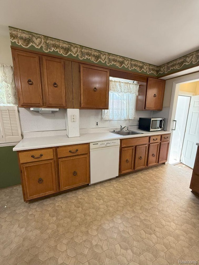 4017 Woodworth St, Dearborn, MI 48126 - kitchen with dishwasher, stainless steel microwave, a sink, light countertops, and brown cabinetry