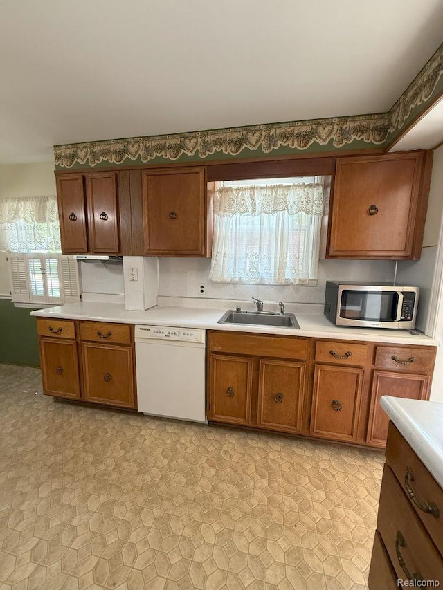 4017 Woodworth St, Dearborn, MI 48126 - kitchen with dishwasher, stainless steel microwave, brown cabinetry, a sink, and light countertops
