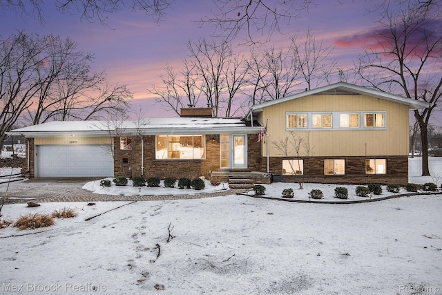20405 Thorofare Rd, Grosse Ile, MI 48138 - split level home featuring a chimney, a garage, driveway, and brick siding