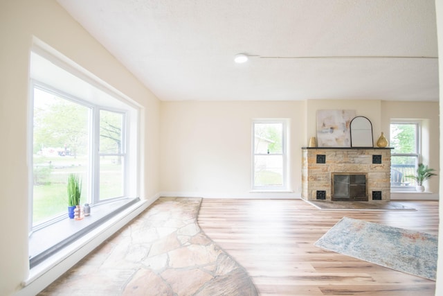 1658 Joslyn Rd, Muskegon, MI 49445 - unfurnished living room with a fireplace, baseboards, and light wood finished floors