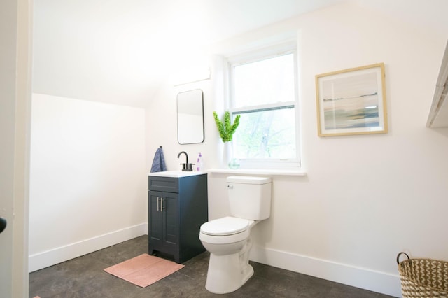 1658 Joslyn Rd, Muskegon, MI 49445 - bathroom featuring toilet, vanity, baseboards, and vaulted ceiling