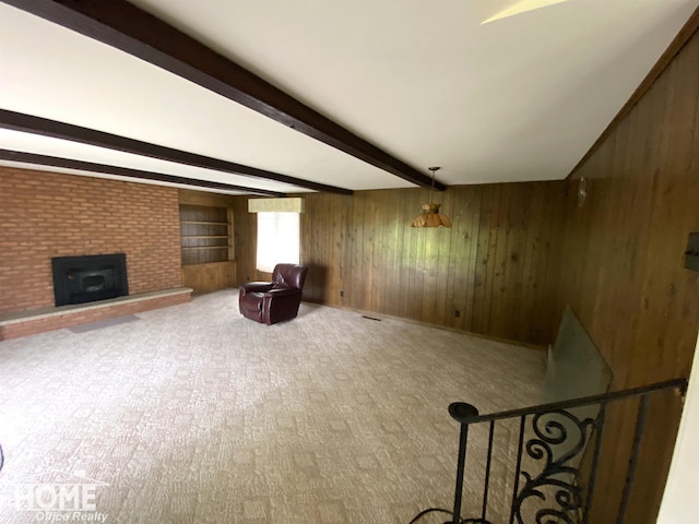 2437 S State Rd, Corunna, MI 48817 - unfurnished room with wooden walls, beam ceiling, a fireplace, and carpet floors