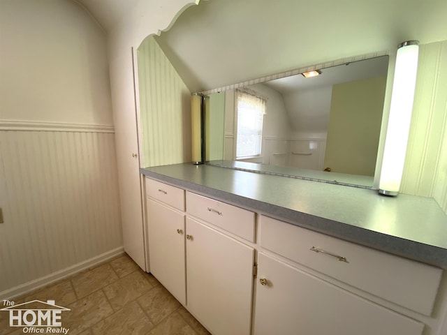 2437 S State Rd, Corunna, MI 48817 - kitchen featuring vaulted ceiling, white cabinets, and light stone finish floors