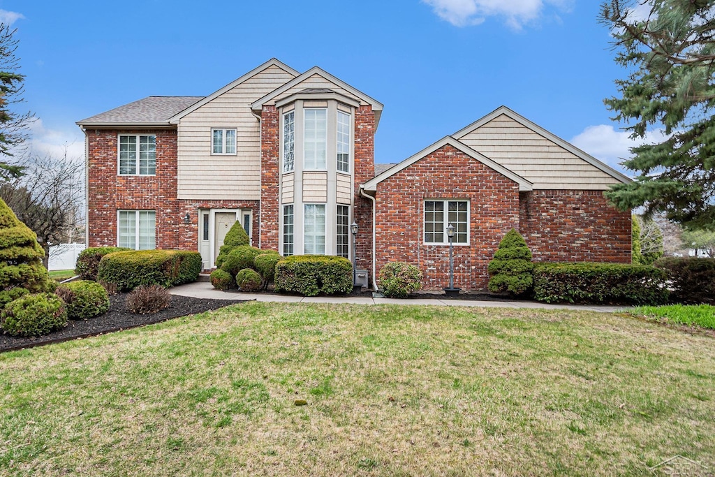 4600 S White Trillium Dr, Saginaw, MI 48603 - traditional-style house with a front lawn and brick siding