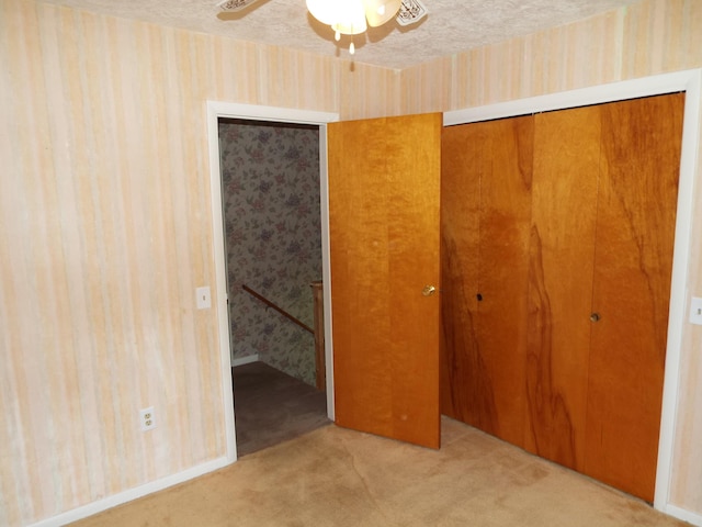 407 Doty St, Leslie, MI 49251 - unfurnished bedroom with wallpapered walls, a closet, carpet floors, and ceiling fan