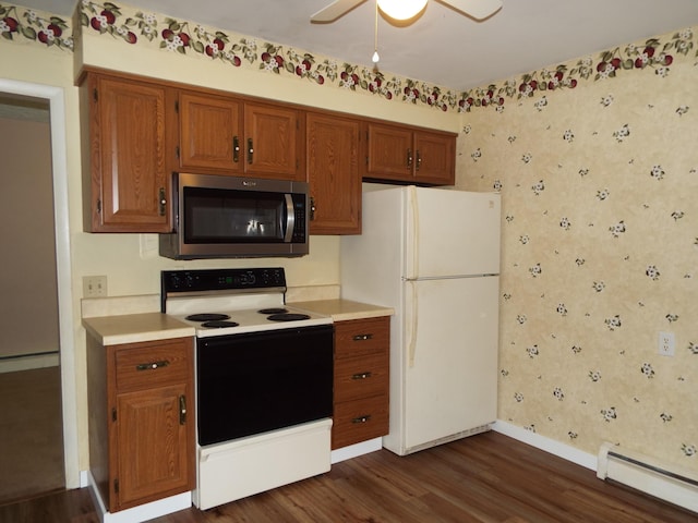 407 Doty St, Leslie, MI 49251 - kitchen featuring stainless steel microwave, electric stove, a baseboard radiator, freestanding refrigerator, and dark wood-type flooring
