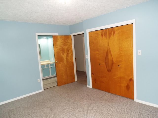 407 Doty St, Leslie, MI 49251 - unfurnished bedroom with carpet floors, a closet, baseboards, a textured ceiling, and ensuite bath