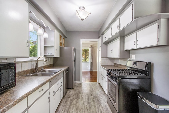1804 Lakeway Ave, Kalamazoo, MI 49001 - kitchen with appliances with stainless steel finishes, a sink, white cabinetry, light wood-style flooring, and tasteful backsplash