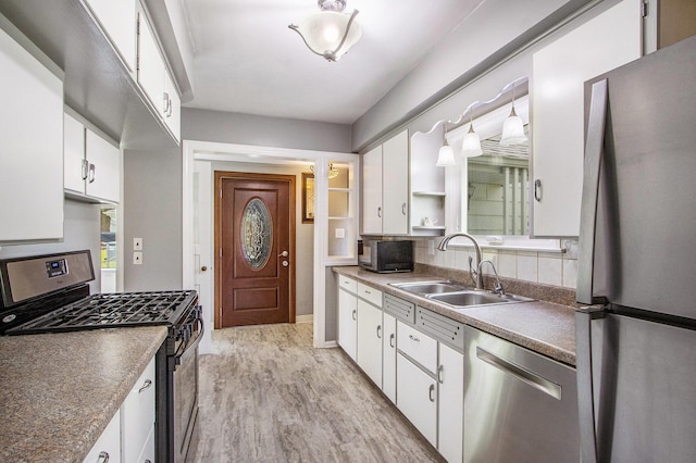 1804 Lakeway Ave, Kalamazoo, MI 49001 - kitchen featuring appliances with stainless steel finishes, a sink, white cabinetry, open shelves, and light wood-style flooring