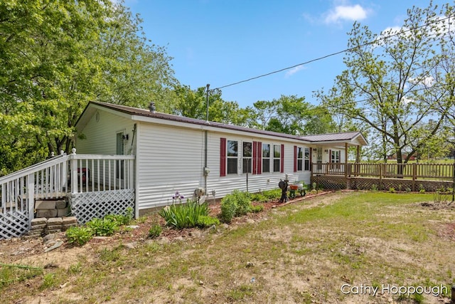3079 E Bluewater Hwy, Ionia, MI 48846 - rear view of house with a wooden deck and a yard