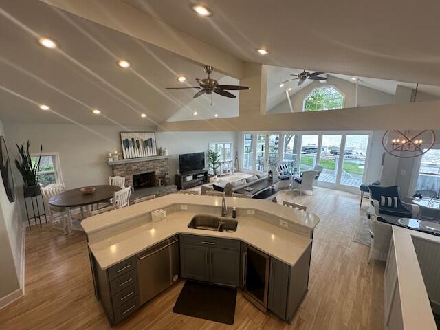 9393 Fraulin Dr, Richland, MI 49083 - kitchen featuring a sink, open floor plan, lofted ceiling, light countertops, and a stone fireplace
