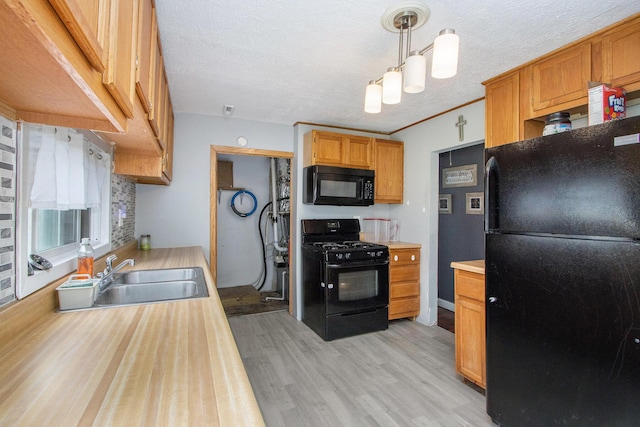3924 Oakland Dr, Kalamazoo, MI 49008 - kitchen featuring black appliances, light countertops, light wood-type flooring, a sink, and a textured ceiling