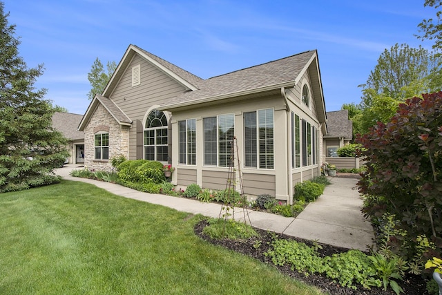933 Bridge Crest Dr SE, Ada, MI 49301 - view of property exterior with a shingled roof and a yard