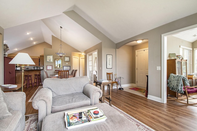 933 Bridge Crest Dr SE, Ada, MI 49301 - living area with lofted ceiling, wood finished floors, baseboards, and arched walkways