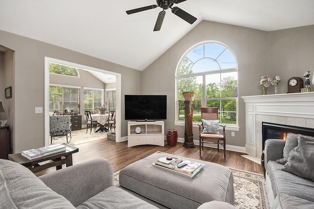 933 Bridge Crest Dr SE, Ada, MI 49301 - living room featuring lofted ceiling, a ceiling fan, healthy amount of natural light, a fireplace, and wood finished floors